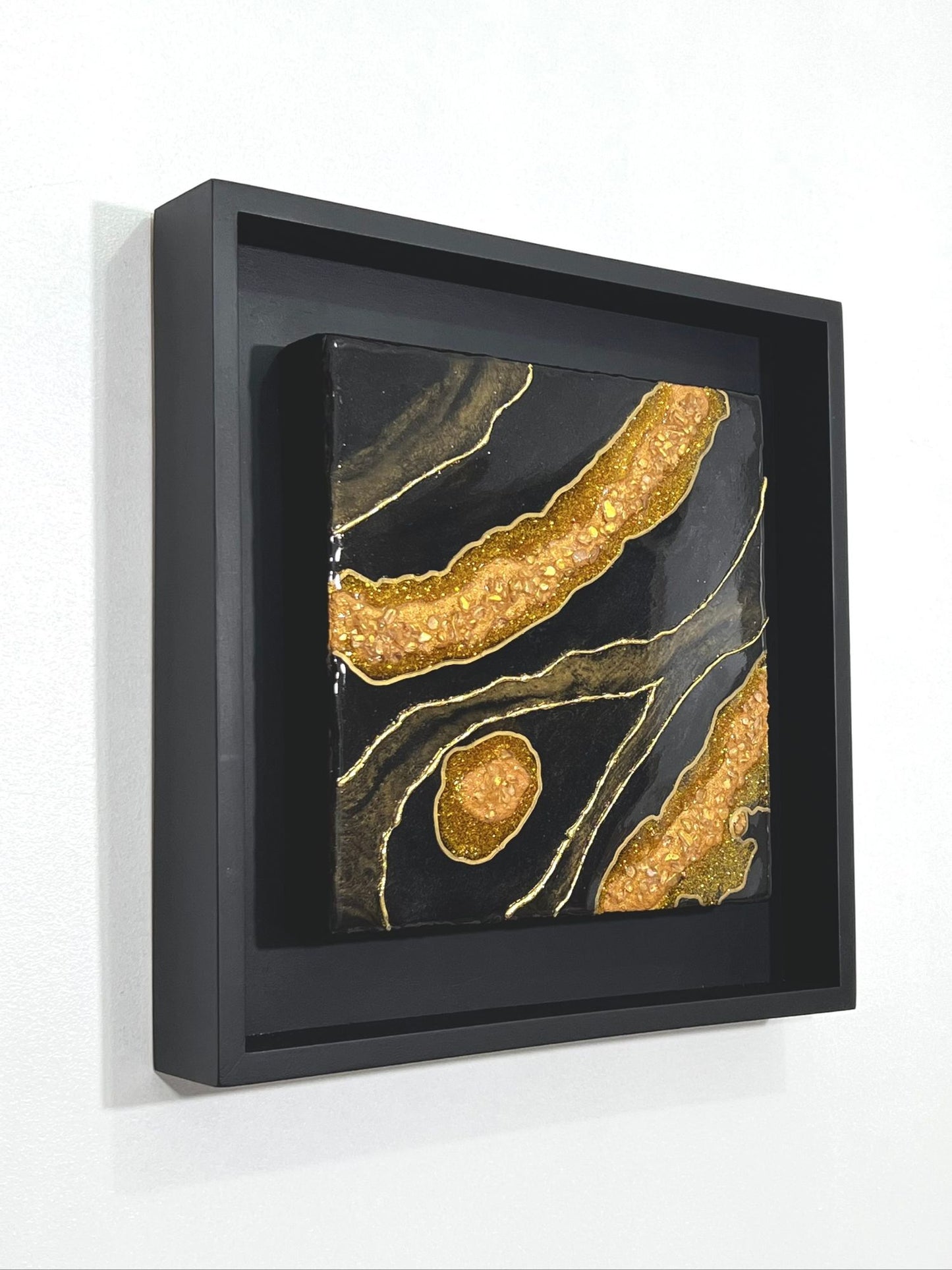 12" x 12" Black and Gold Resin Geode wall art in black wood frame.